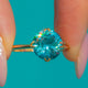 Round blue Zircon solitaire in a raised six-claw 18ct Gold setting